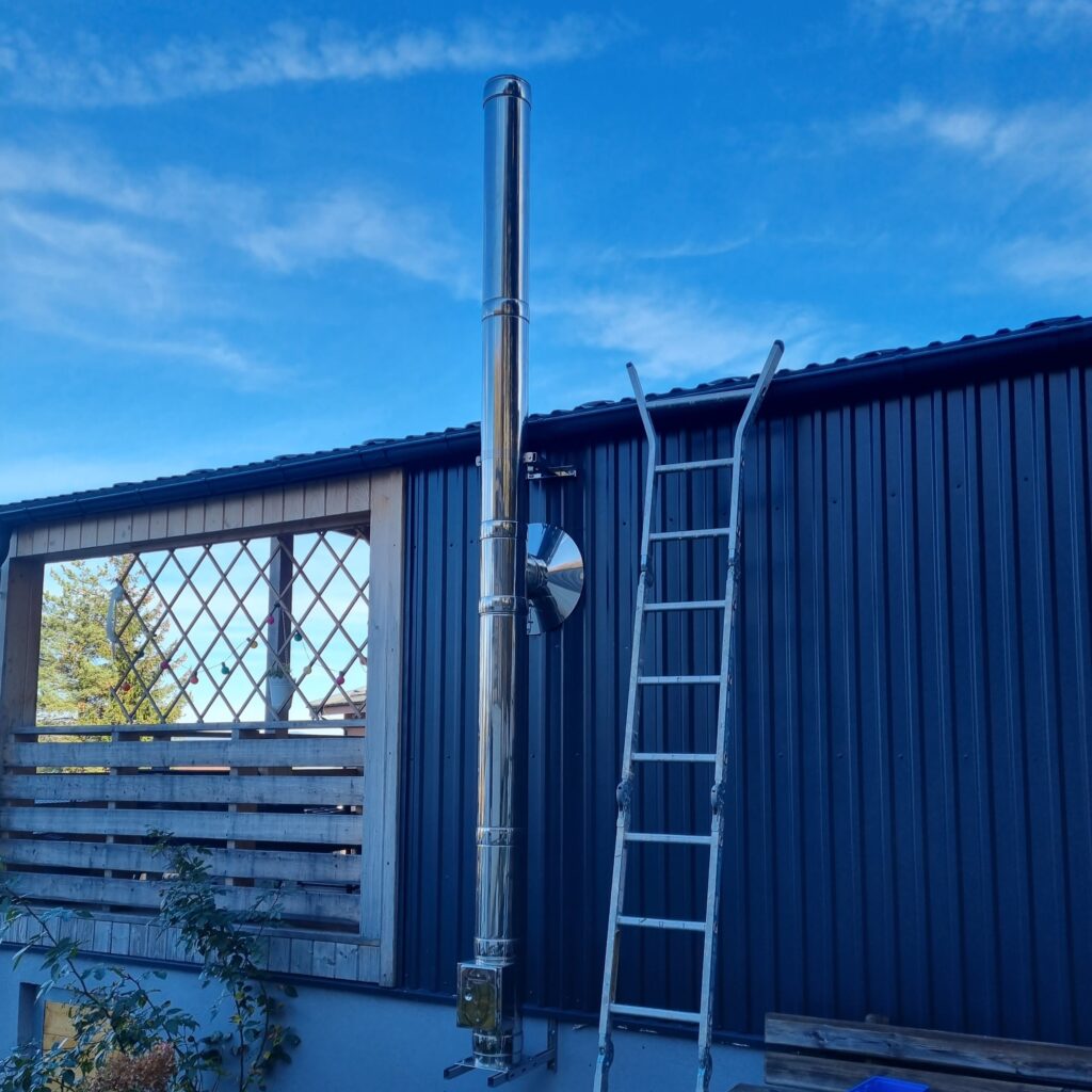 Silberner Kamin vor metallener Wand