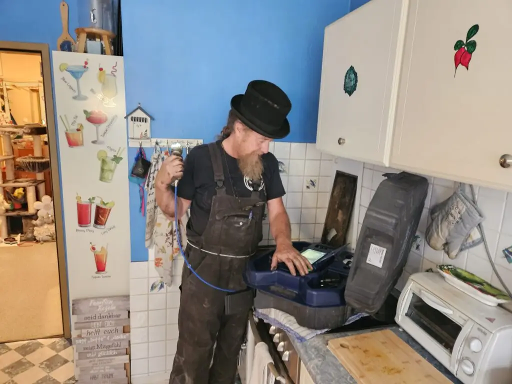 Rauchfangkehrer macht seinen Job mit Messgerät