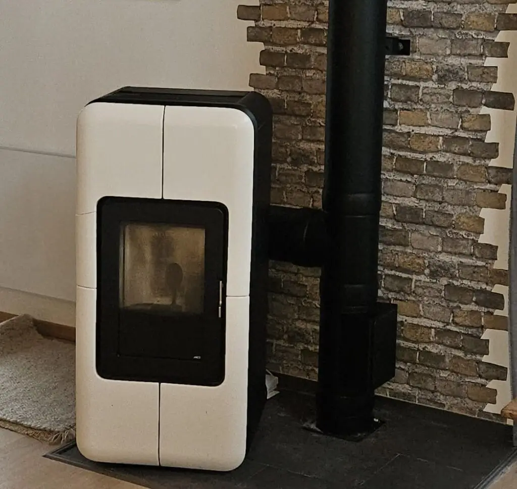 weißer Ofen vor gemauerter Wand Rauchfangkehrer Lenk