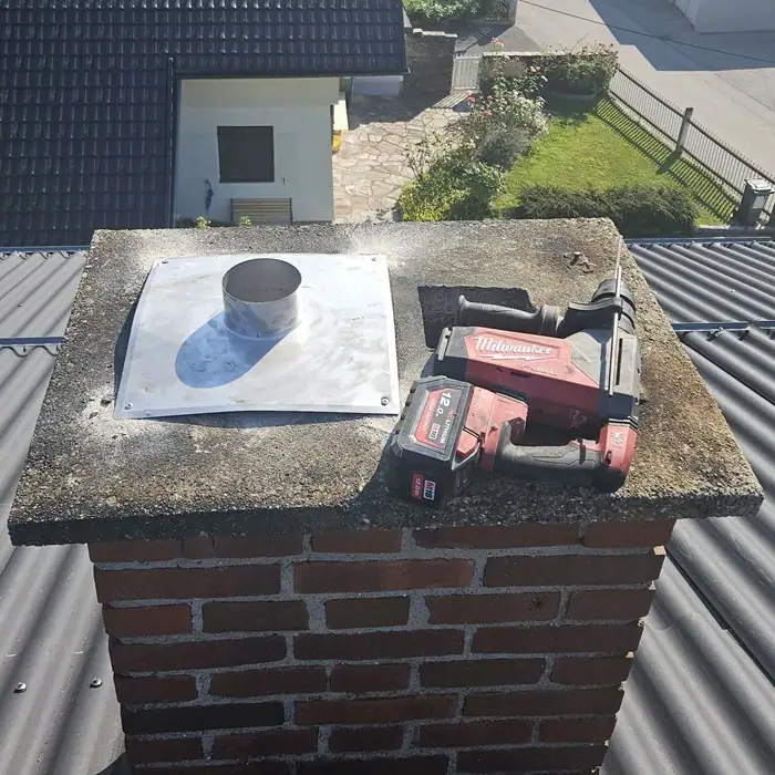 Silberner Kamin mit rot schwarzem Werkzeug darauf liegend