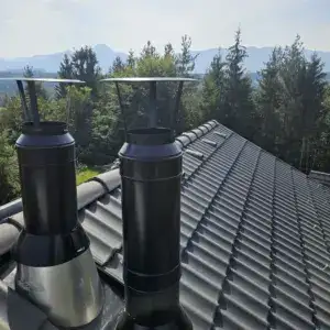 Zwei schwarze Kamine vor klarem Himmel