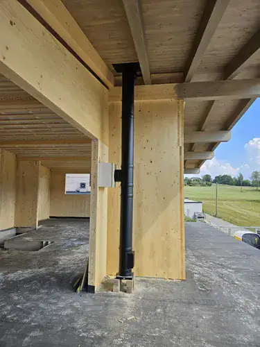 Kaminbau in Neubau, schwarzer Kamin vor Holzwand