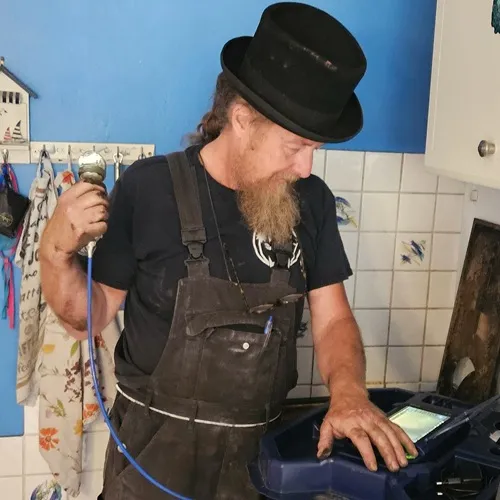 Rauchfangkehrer macht seinen Job mit Messgerät