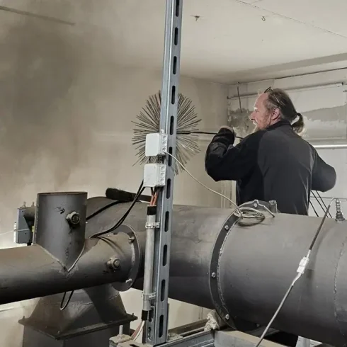 Quadratisch_Rauchfangkehrer bei der Arbeit Villacher Rauchfangkehrer mit Kehrbürste
