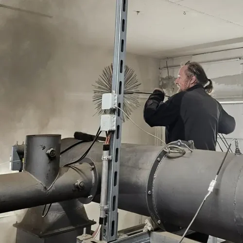 Quadratisch_Rauchfangkehrer bei der Arbeit Villacher Rauchfangkehrer mit Kehrbürste